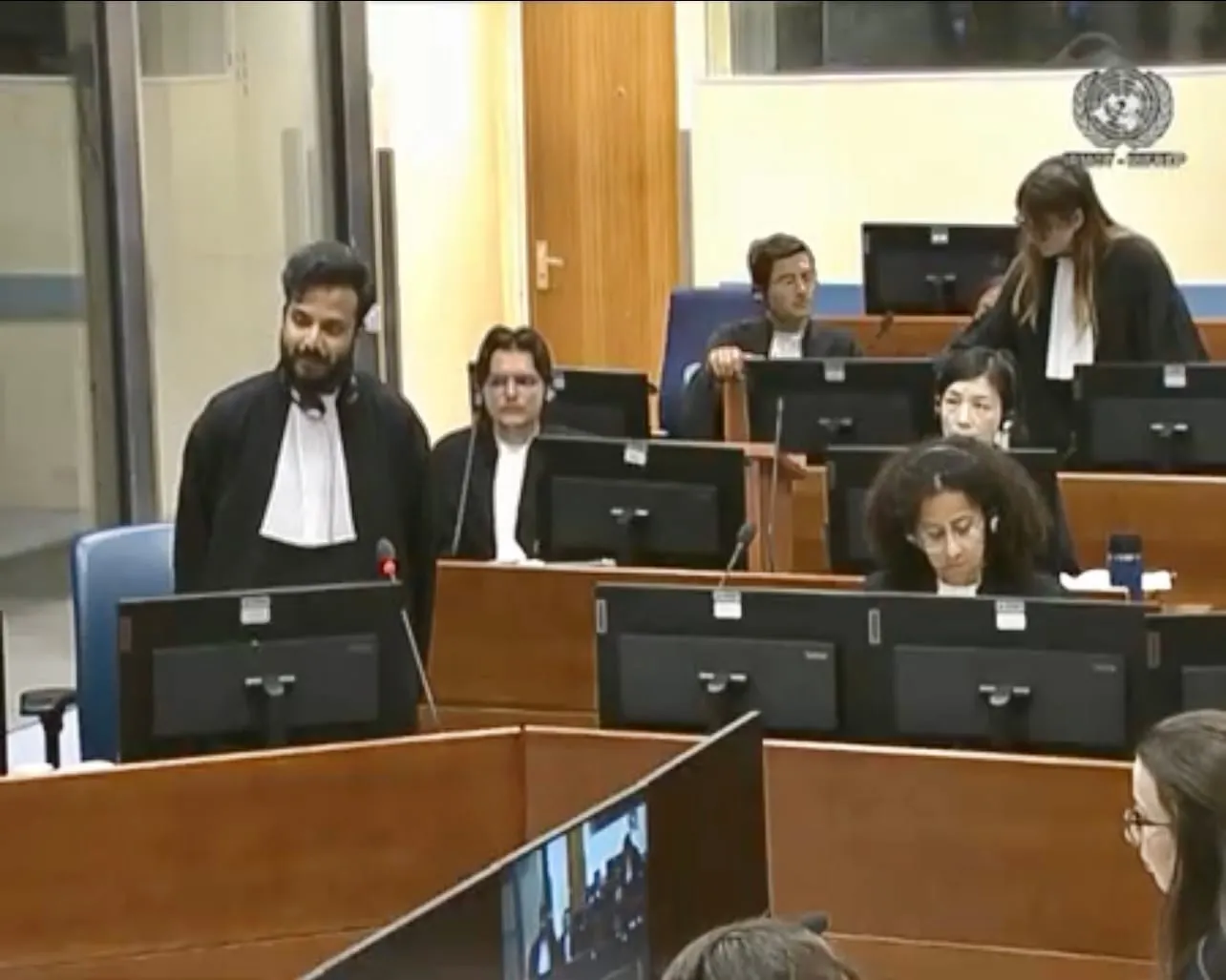Farhaan Ahmed standing among fellow participants in the IRMCT courtroom during the 2023 Mock Trial and Training