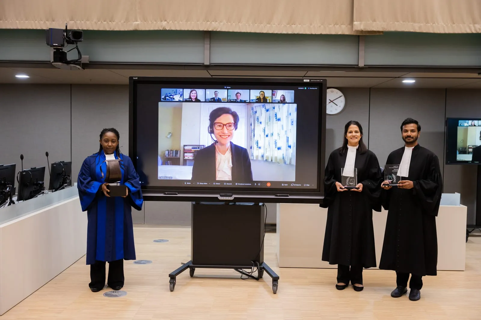 Judges, including Farhaan Ahmed, presenting awards to remotely-connected finalists shown on screen at the 2022 ICC Moot Court Competition Final