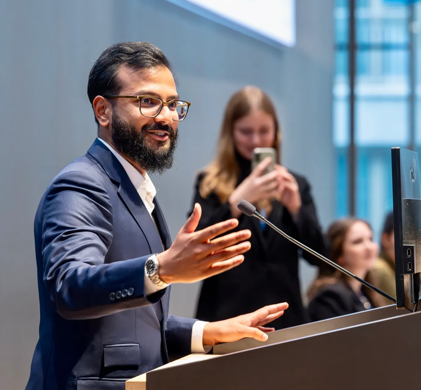 Farhaan Ahmed speaking at a podium